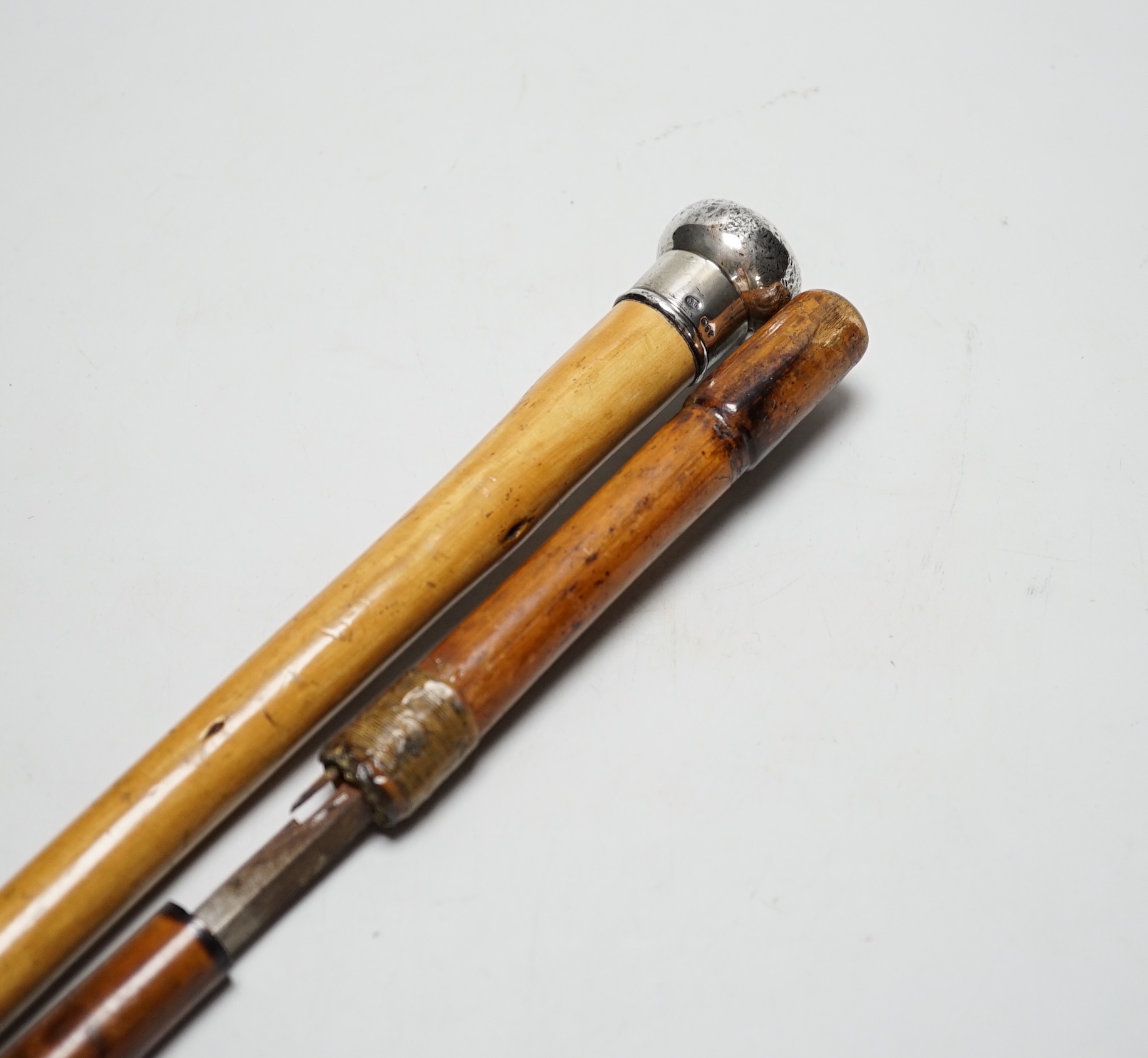 A Victorian sword stick and a silver topped walking cane